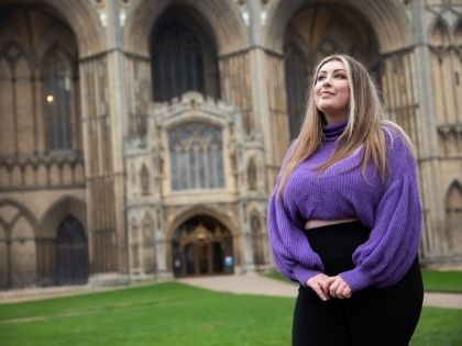 Female student in front of some of Cambridge's impressive architecture