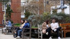 Students sitting on benches - ARU Cambridge campus