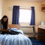 Student in accommodation sitting in bed